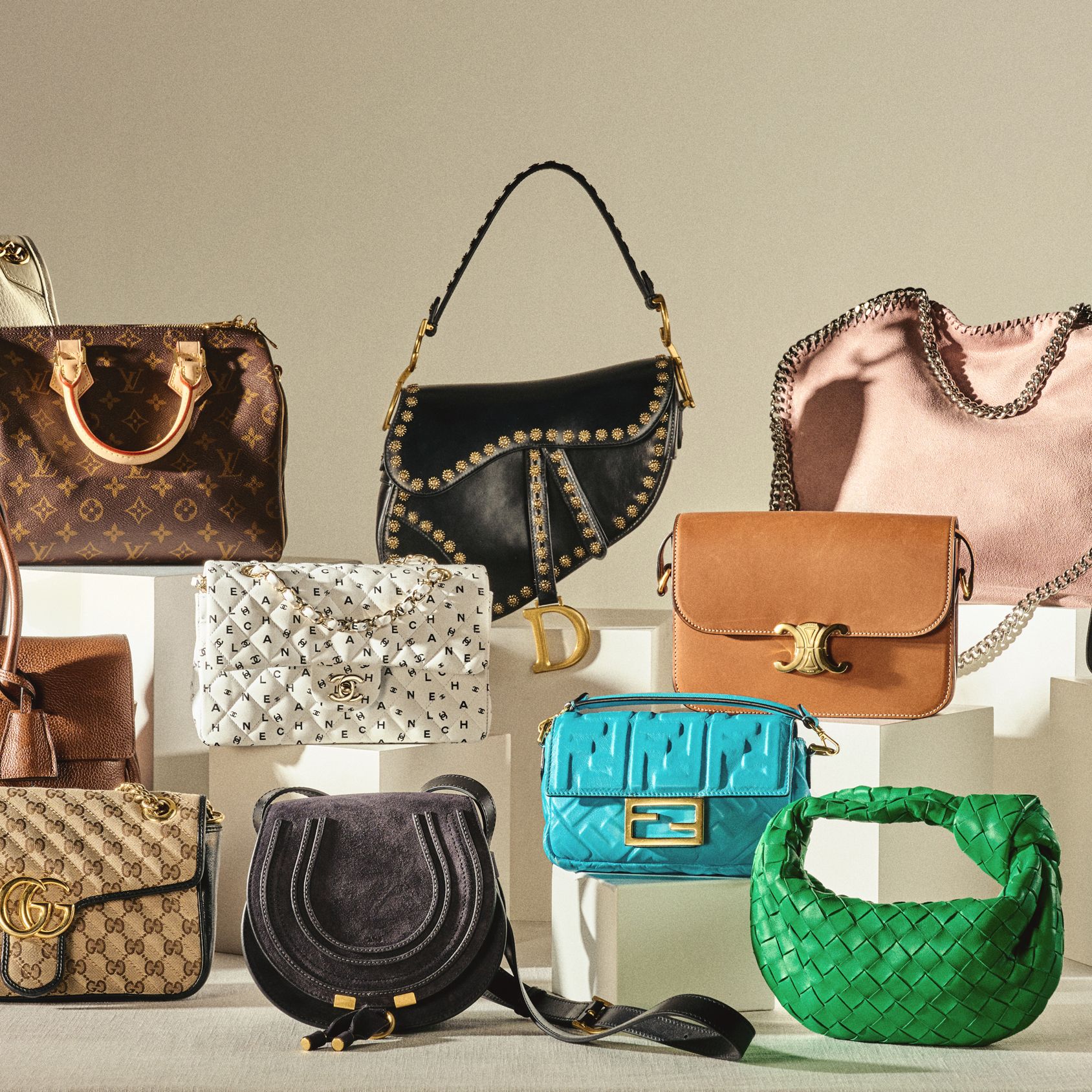 Designer handbags and luxury accessories arranged on marble